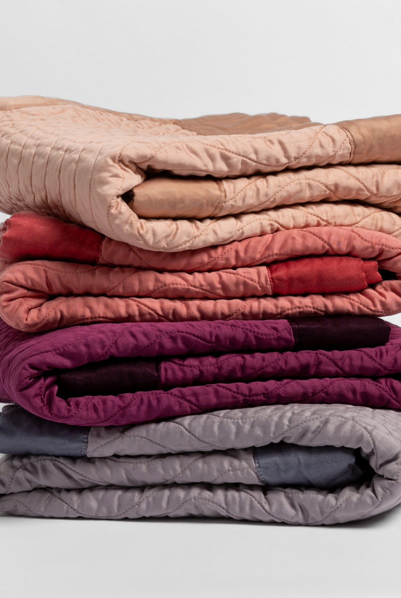 [allvariants]: stack of quilted cotton sateen baby blankets in Rouge, Poppy, fig and french lavender