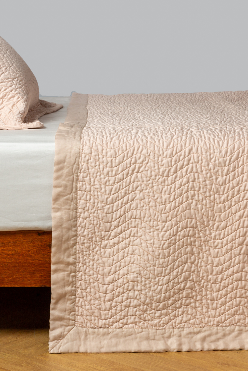 Pearl: quilted cotton sateen coverlet with matching sham on a winter white fitted sheet - side view. 