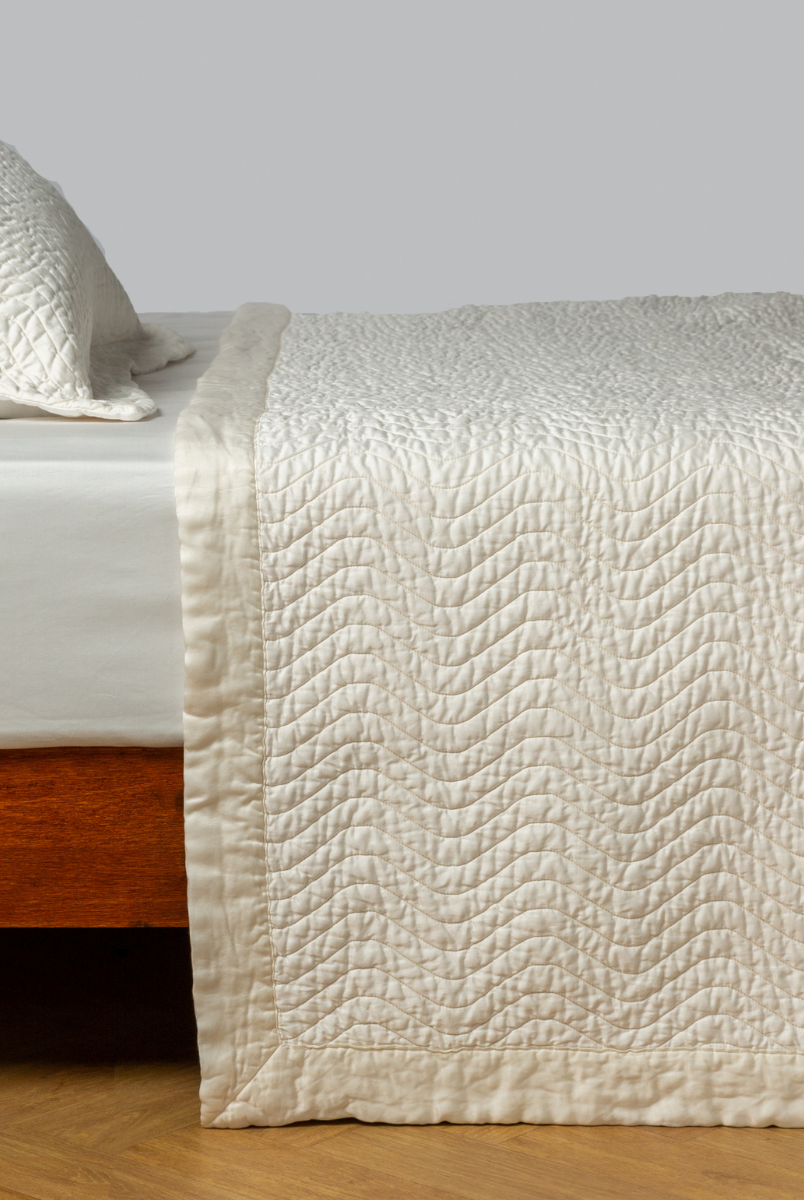 Winter White: quilted cotton sateen coverlet with matching sham on a winter white fitted sheet - side view. 