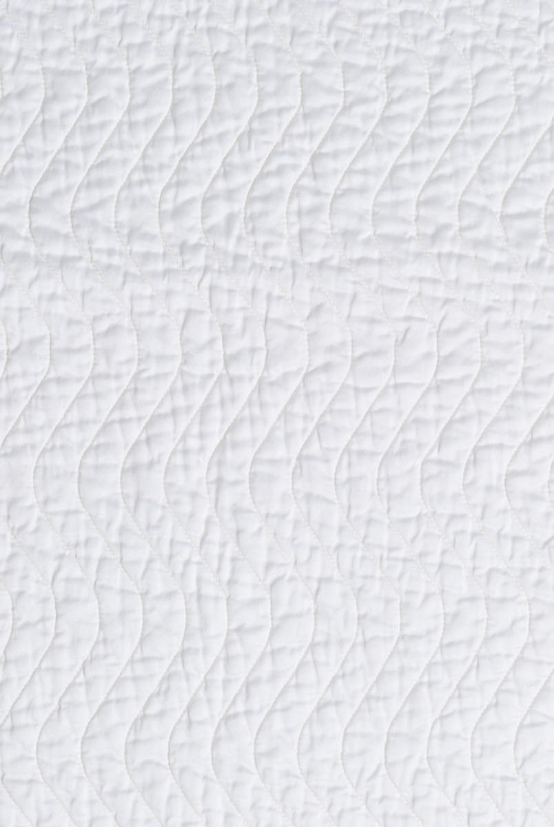 White: A close up of quilted cotton sateen fabric in classic white.