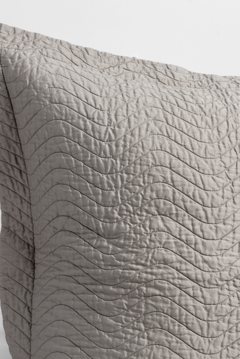 Fog: a close up of a pillow corner showing the flange framing quilted cotton sateen shot against a white background. 