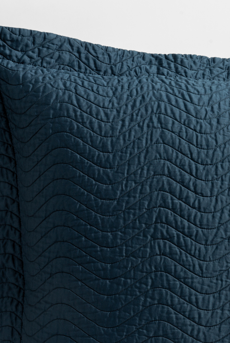 Midnight: a close up of a pillow corner showing the flange framing quilted cotton sateen shot against a white background. 