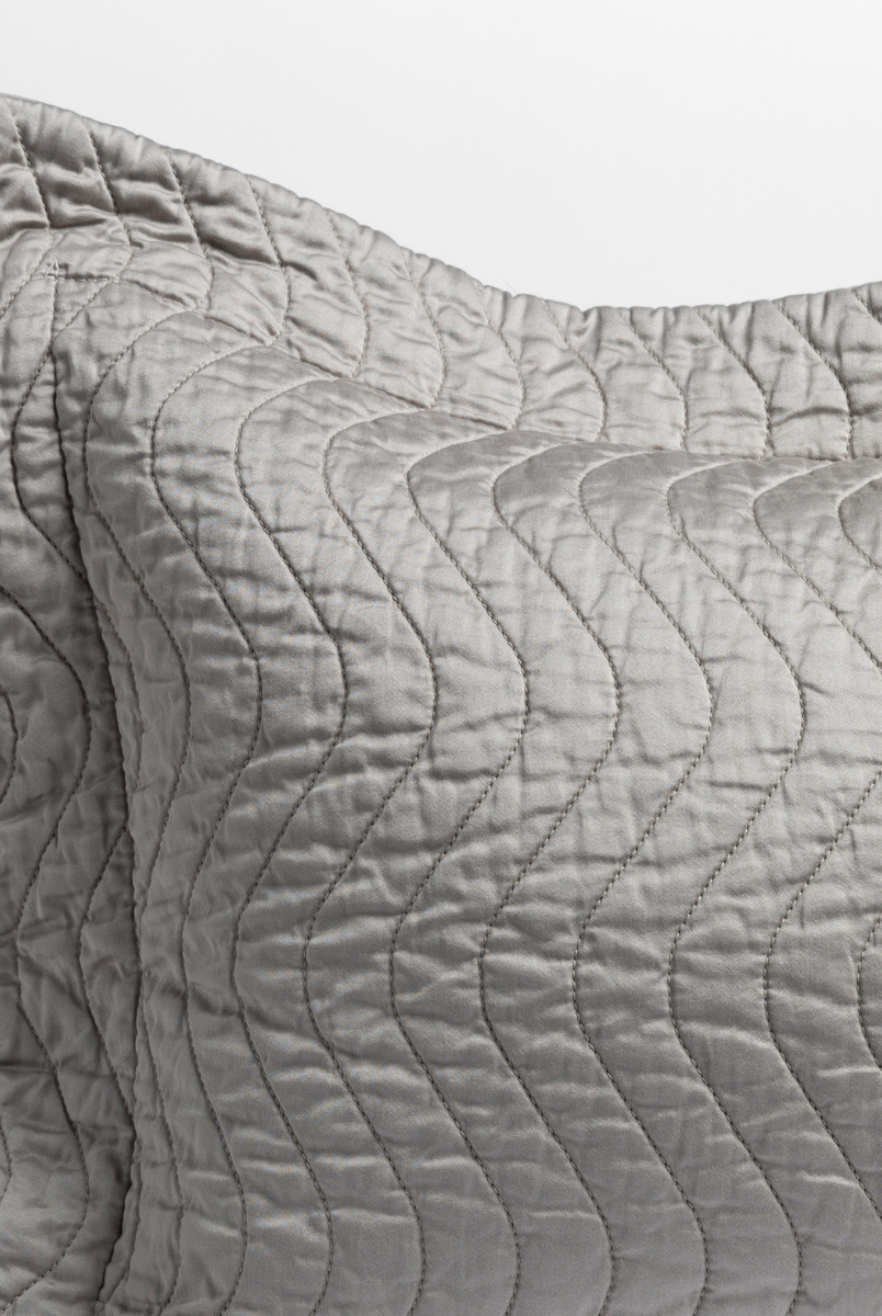 Mineral: close up of the corner of a quilted cotton sateen pillow sham - shot against a white background. 